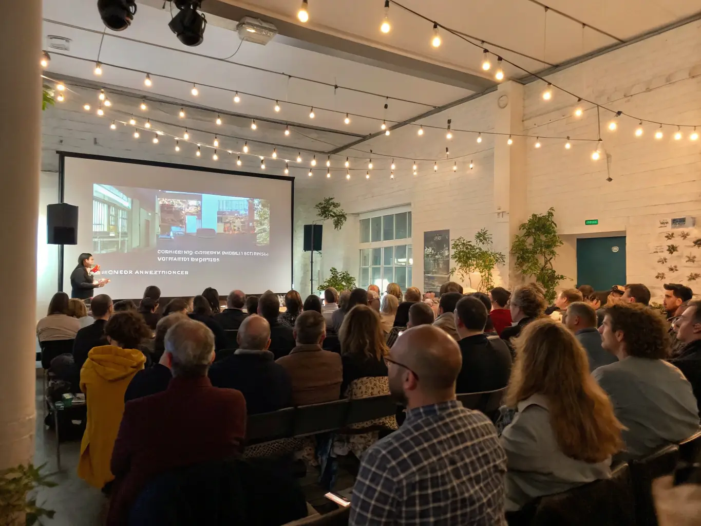 A projector displaying a vibrant DVD diaporama on a screen in a community center, illustrating CASTELIER-PHOTO's engagement with public distribution.